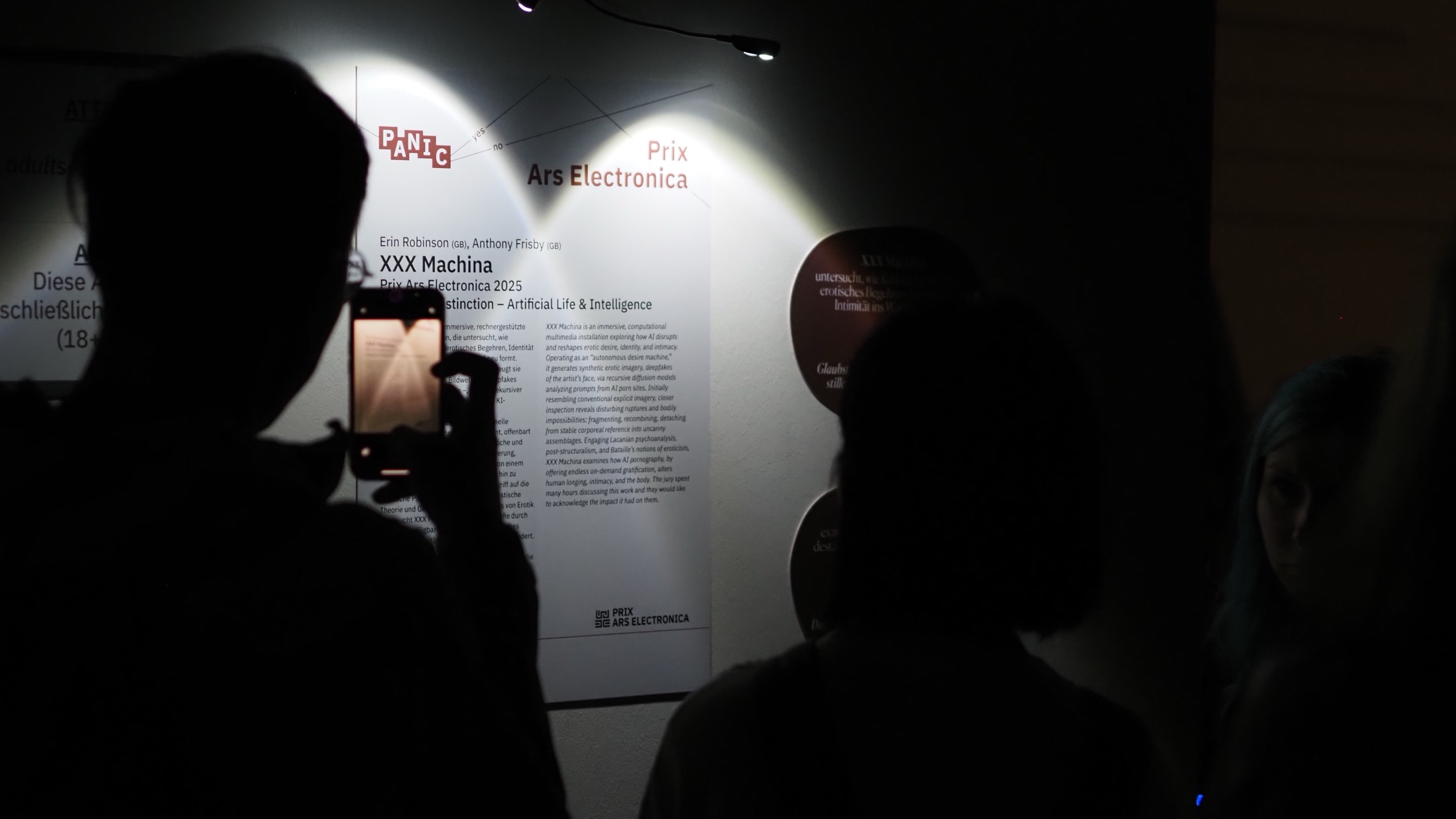 Visitors photograph the XXX Machina wall text at the Prix Ars Electronica 2025 exhibition in Linz.